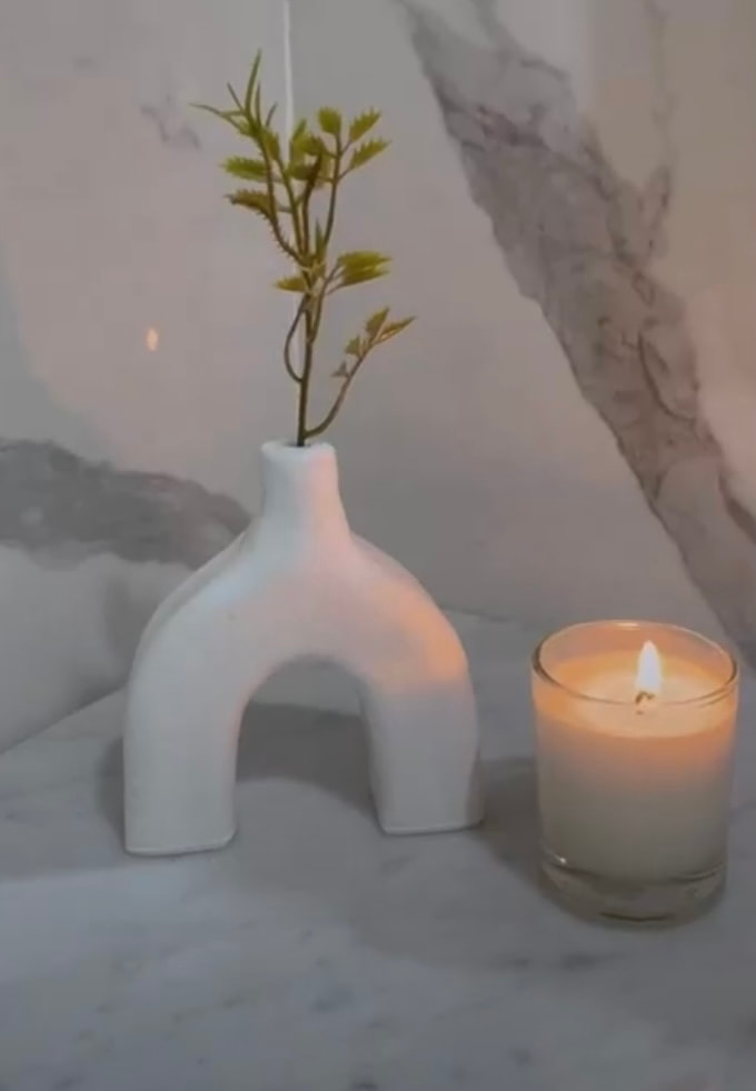 White Candle next to White Vase against Marble background